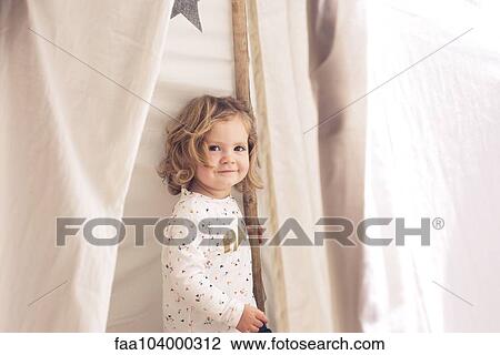 Little girl smiling in tent, portrait View Large Photo Image Stock Image - Little girl smiling in tent, portrait. Fotosearch