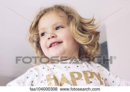 Stock Photo - Little girl smiling, looking away, portrait. Fotosearch
