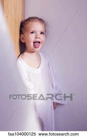 Stock Photography - Little girl sticking out her tongue, portrait. Fotosearch