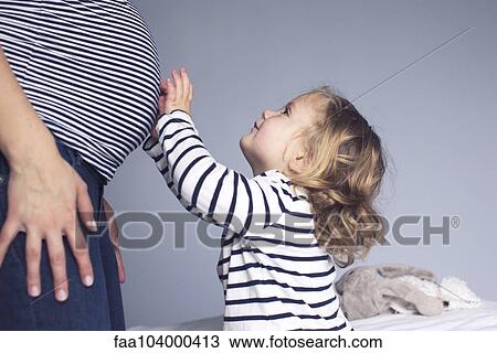 Little girl touching mother's pregnant stomach, cropped View Large Photo Image Stock Image - Little girl touching mother's pregnant stomach, cropped. Fotosearch