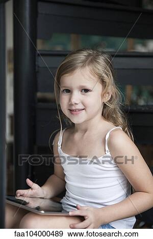 Stock Photo - Little girl using digital tablet, portrait. Fotosearch