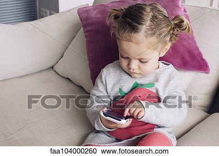 Little girl using smartphone View Large Photo Image Stock Image - Little girl using smartphone. Fotosearch