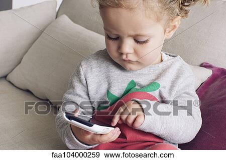 Stock Photo - Little girl using smartphone. Fotosearch