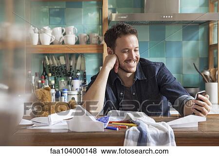 Stock Photo - Man at home using smartphone. Fotosearch