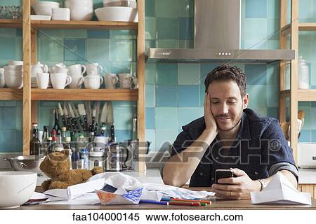 Stock Photography - Man at home using smartphone. Fotosearch