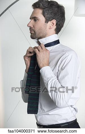 Man tying tie View Large Photo Image Stock Image - Man tying tie. Fotosearch