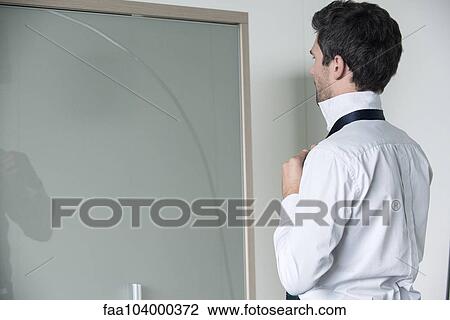 Stock Image - Man tying tie. Fotosearch