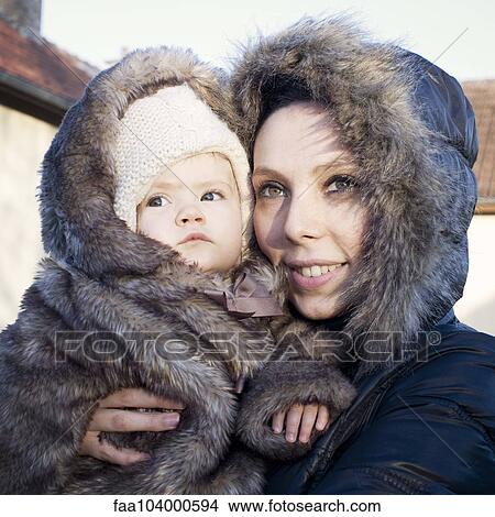 Picture - Mother and baby dressed in winter coats, portrait. Fotosearch