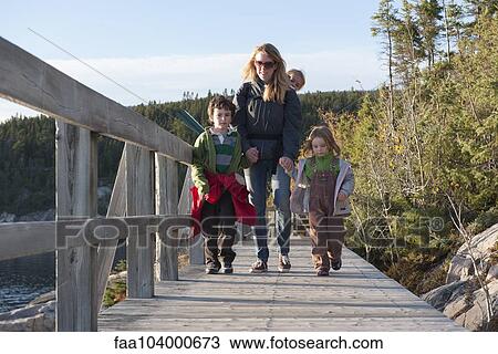 Stock Image - Mother and three children enjoying nature walk. Fotosearch