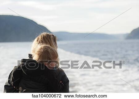 Stock Image - Mother and young son looking at tranquil lake view. Fotosearch