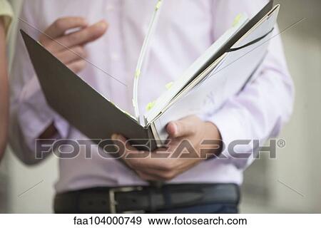 Stock Photo - Office worker flipping through binder. Fotosearch