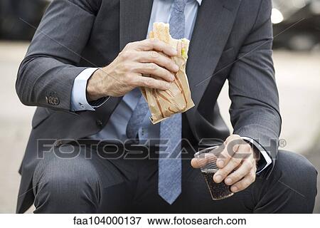 Stock Photo - Office worker having lunch outdoors. Fotosearch