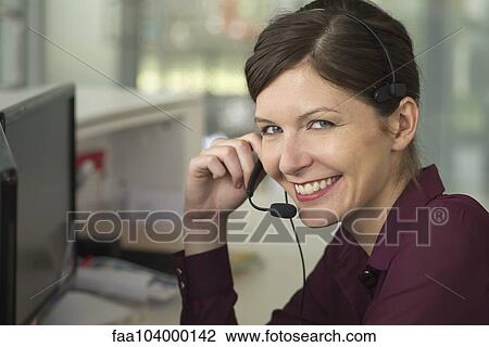 Office worker making phone call using hands-free device View Large Photo Image Stock Image - Office worker making phone call using hands-free device. Fotosearch