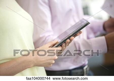 Picture - Office worker using digital tablet, cropped. Fotosearch