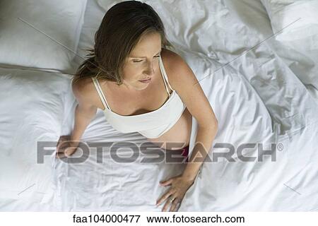 Stock Photo - Preganant woman waking up in bed. Fotosearch