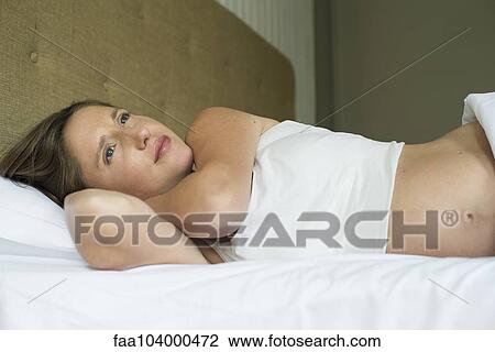 Pregnant woman lying in bed View Large Photo Image Stock Image - Pregnant woman lying in bed. Fotosearch
