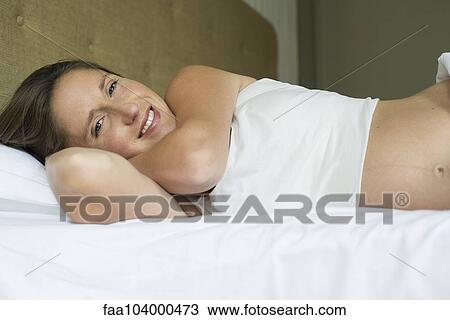 Pregnant woman lying in bed View Large Photo Image Stock Image - Pregnant woman lying in bed. Fotosearch
