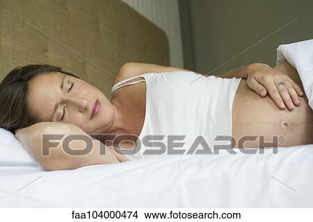 Pregnant woman sleeping in bed View Large Photo Image Picture - Pregnant woman sleeping in bed. Fotosearch