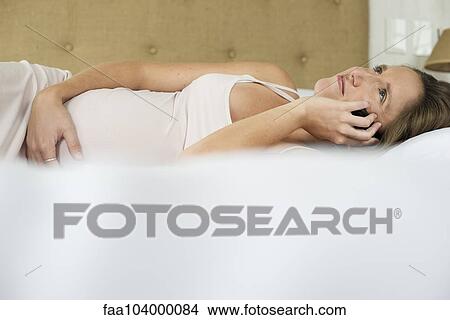 Pregnant woman using cell phone to stay in touch with friends and family View Large Photo Image Picture - Pregnant woman using cell phone to stay in touch with friends and family. Fotosearch