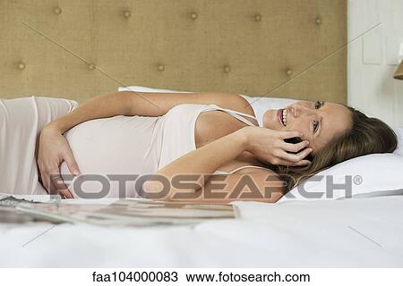 Pregnant woman using cell phone to stay in touch with friends and family View Large Photo Image Stock Image - Pregnant woman using cell phone to stay in touch with friends and family. Fotosearch
