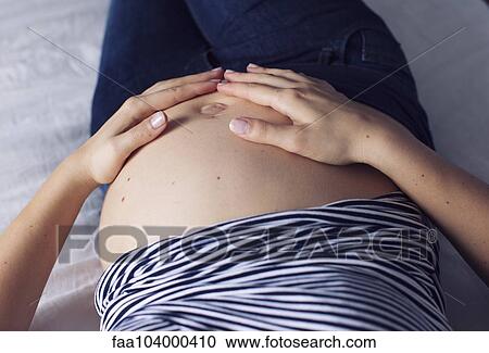Pregnant woman with hands on bare stomach, cropped View Large Photo Image Stock Image - Pregnant woman with hands on bare stomach, cropped. Fotosearch