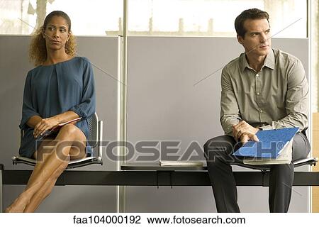 Stock Image - Professionals sitting in waiting room. Fotosearch