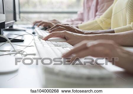 Professionals using desktop computers in training class, cropped View Large Photo Image Stock Photo - Professionals using desktop computers in training class, cropped. Fotosearch