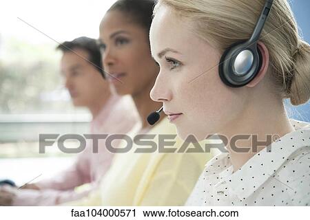 Stock Image - Telemarketers at work in call center. Fotosearch