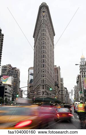 Stock Image - Traffic moves on street near Flatiron Building in Manhattan, New York City, New York, USA. Fotosearch