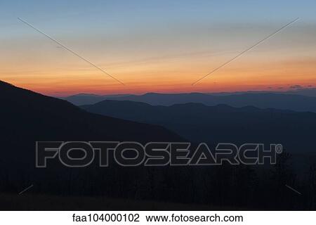 Tranquil sunset in rolling mountain landscape View Large Photo Image Stock Image - Tranquil sunset in rolling mountain landscape. Fotosearch