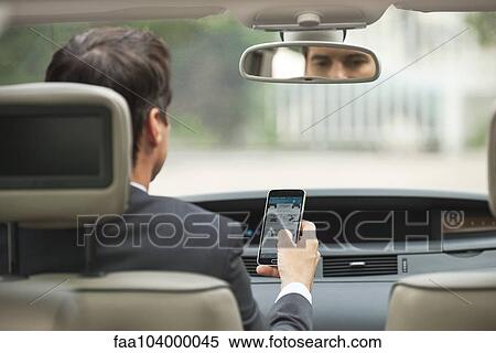 Stock Photography - Using cell phone while driving car. Fotosearch