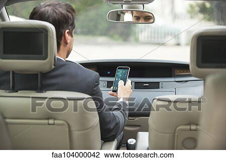 Using smartphone while driving View Large Photo Image Stock Image - Using smartphone while driving. Fotosearch