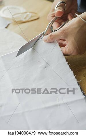 Stock Photo - Woman cutting fabric, cropped. Fotosearch
