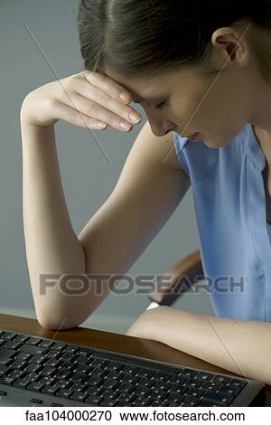 Stock Image - Woman holding head. Fotosearch