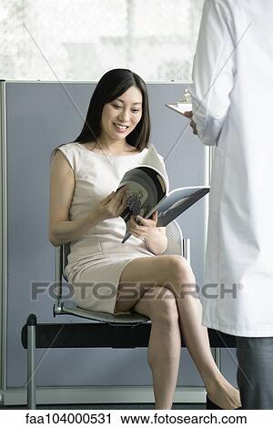 Woman reading magazing in medical waiting room View Large Photo Image Stock Image - Woman reading magazing in medical waiting room. Fotosearch