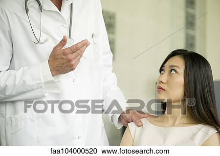 Stock Image - Woman receiving bad news from doctor, cropped. Fotosearch