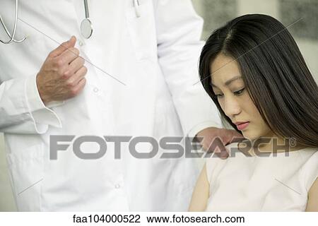 Stock Image - Woman receiving bad news from doctor, cropped. Fotosearch