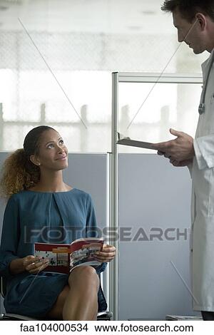Woman talking with doctor in waiting room View Large Photo Image Picture - Woman talking with doctor in waiting room. Fotosearch