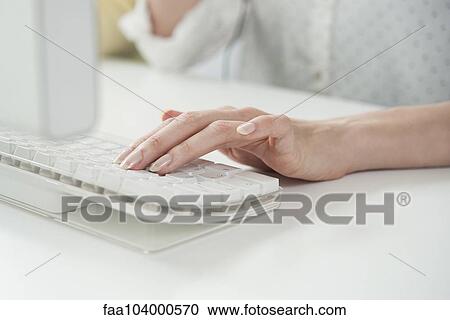 Stock Image - Woman typing on computer keyboard, cropped. Fotosearch