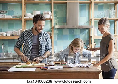 Young daughter drawing at kitchen counter while parents prepare meal View Large Photo Image Stock Photo - Young daughter drawing at kitchen counter while parents prepare meal. Fotosearch