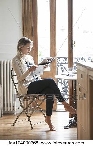 Young woman reading newspaper at home View Large Photo Image Stock Photography - Young woman reading newspaper at home. Fotosearch