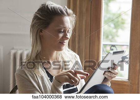 Stock Photo - Young woman using digital tablet. Fotosearch