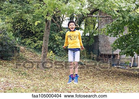 Boy jumping in midair outdoors View Large Photo Image Picture - Boy jumping in midair outdoors. Fotosearch
