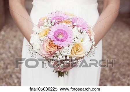 Bride holding bouquet of flowers, cropped View Large Photo Image Stock Photography - Bride holding bouquet of flowers, cropped. Fotosearch
