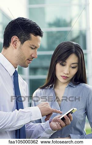 Business colleagues looking at smartphone View Large Photo Image Stock Image - Business colleagues looking at smartphone. Fotosearch
