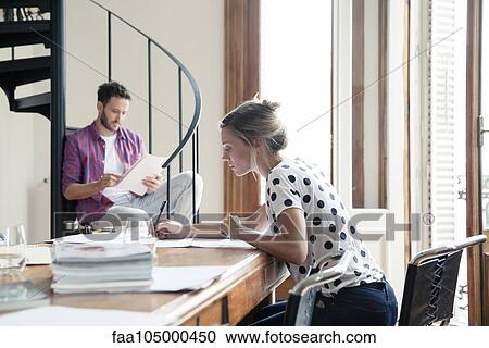 Stock Image - Business partners engrossed in work. Fotosearch