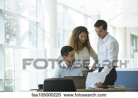 Business professionals reviewing document together View Large Photo Image Stock Image - Business professionals reviewing document together. Fotosearch