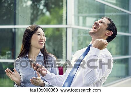 Stock Image - Businessman celebrating good news with colleague. Fotosearch