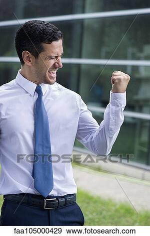 Businessman clenching fist in victory View Large Photo Image Stock Photo - Businessman clenching fist in victory. Fotosearch