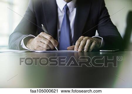Stock Image - Businessman doing paperwork. Fotosearch